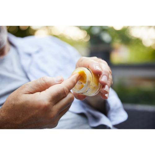 Person applying CBD salve for pain and inflammation relief